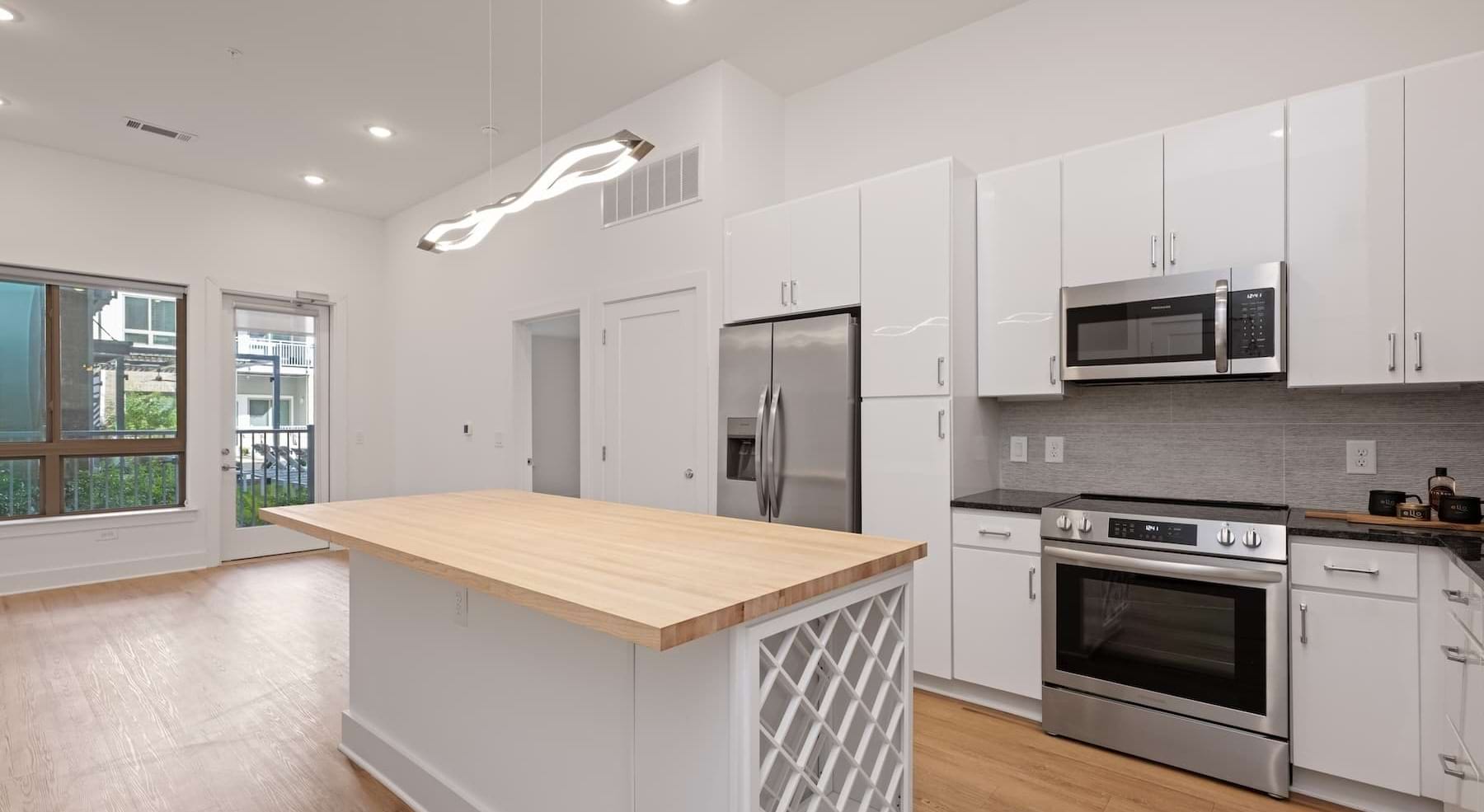 kitchen with white cabinets, an island and wooden accents