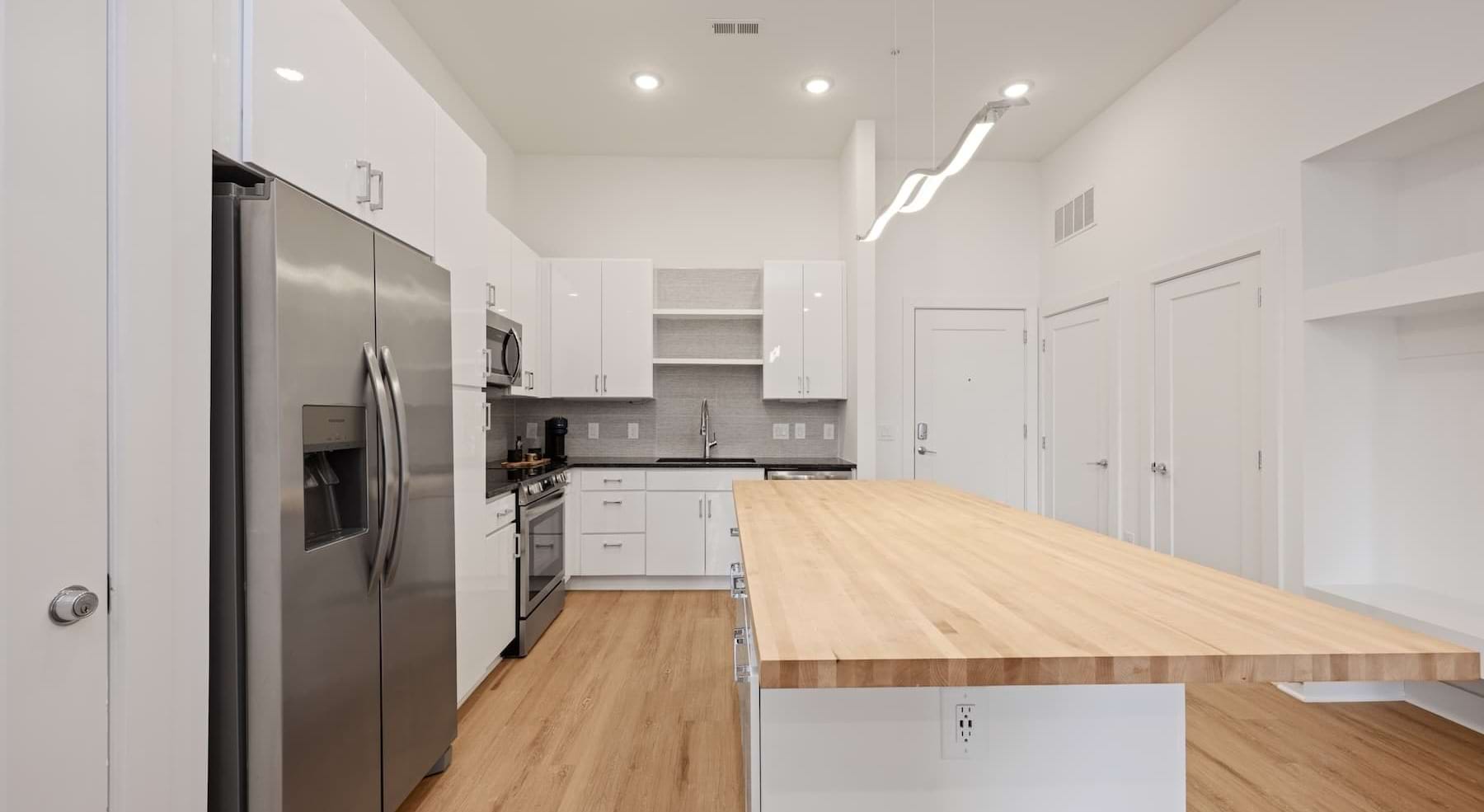 kitchen with white cabinets, an island and wooden accents