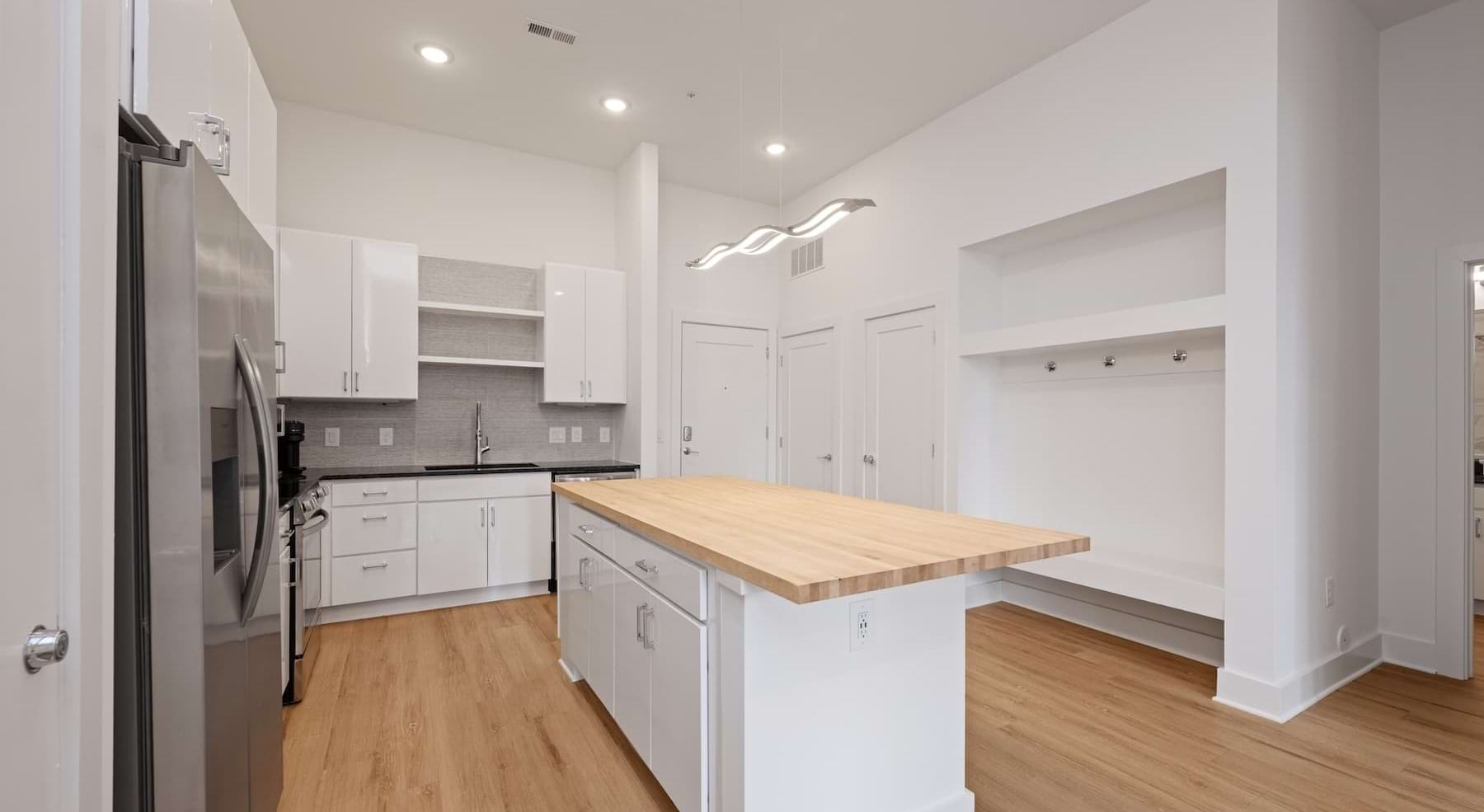 kitchen with white cabinets, an island and wooden accents