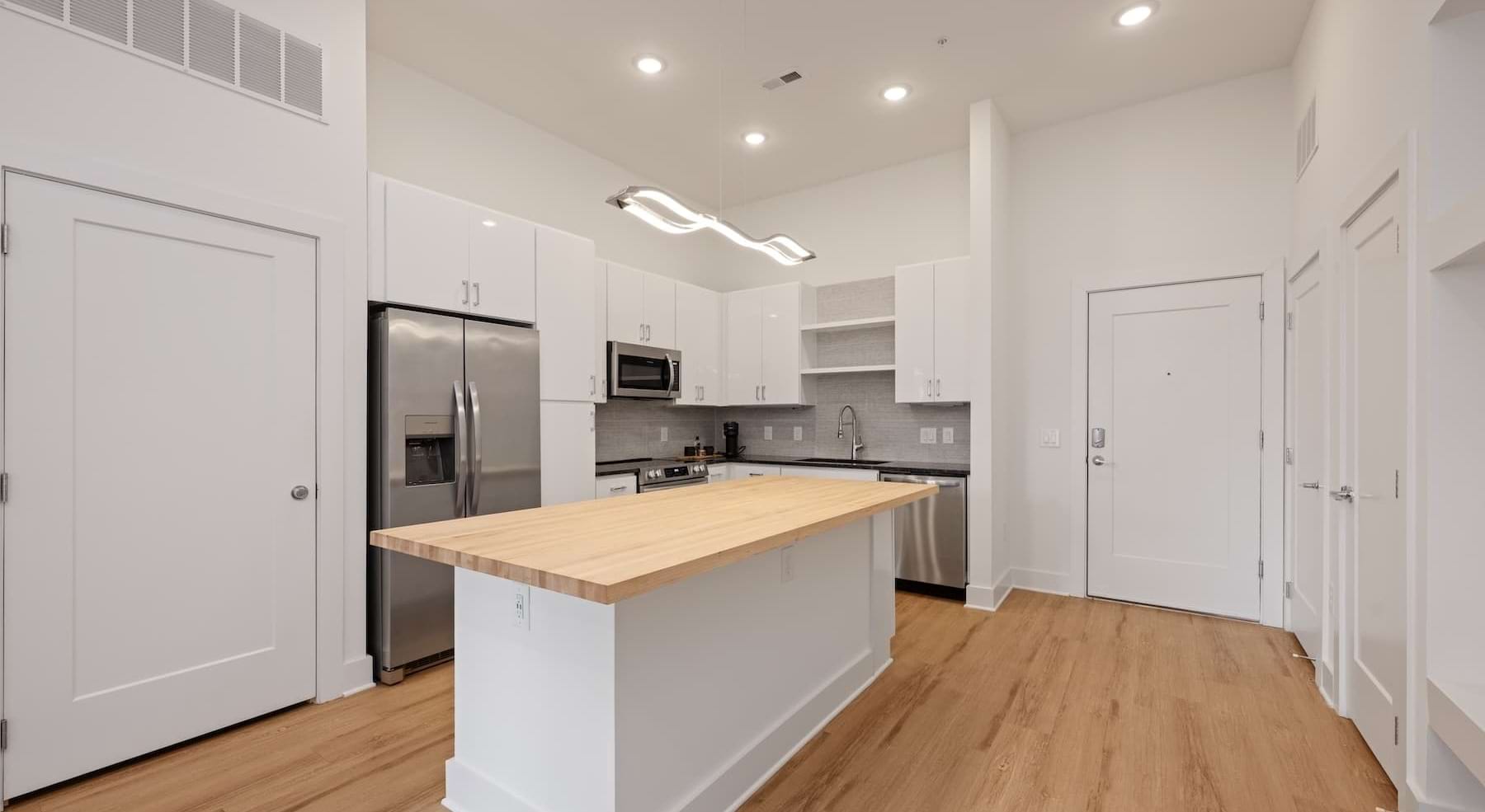 kitchen with white cabinets, an island and wooden accents