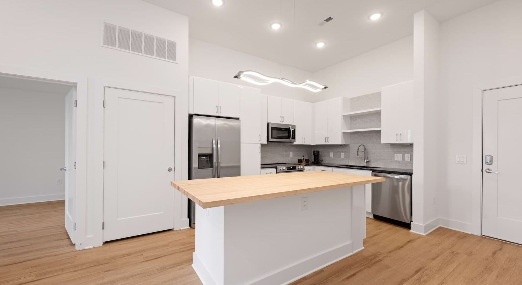 kitchen with white cabinets, an island and wooden accents